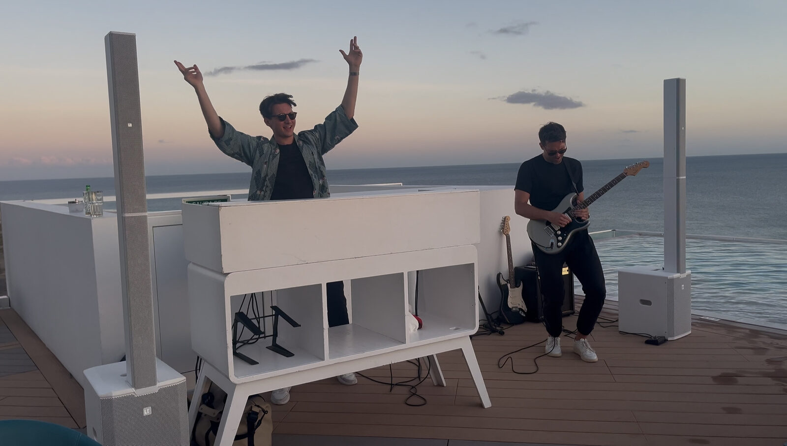 DJ Yannick Penz mit Live-Gitarrist bei Sonnenuntergang auf einer Dachterrasse