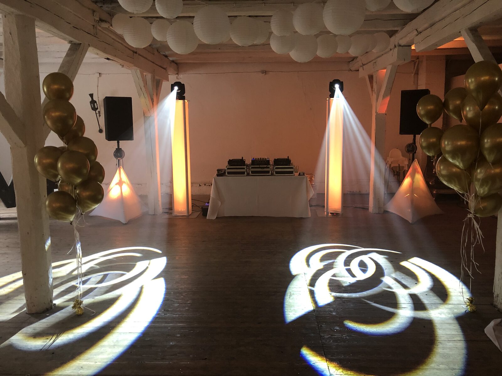 Goldene Hochzeitsdekoration mit Lichtsäulen und DJ-Equipment