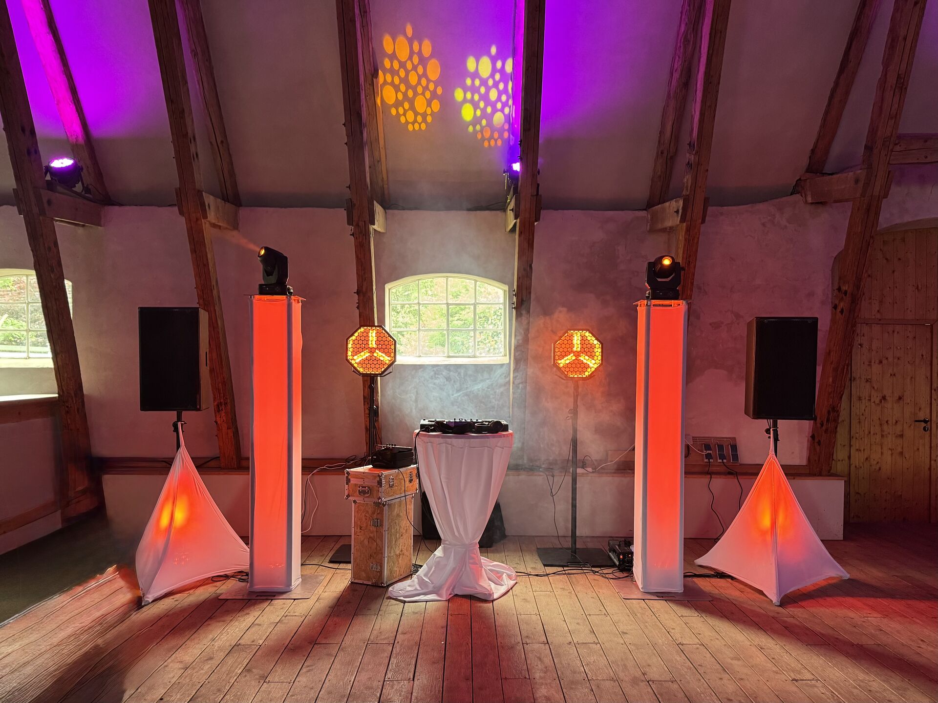Elegantes DJ-Setup mit Lichttechnik bei einer Hochzeit in historischer Scheune